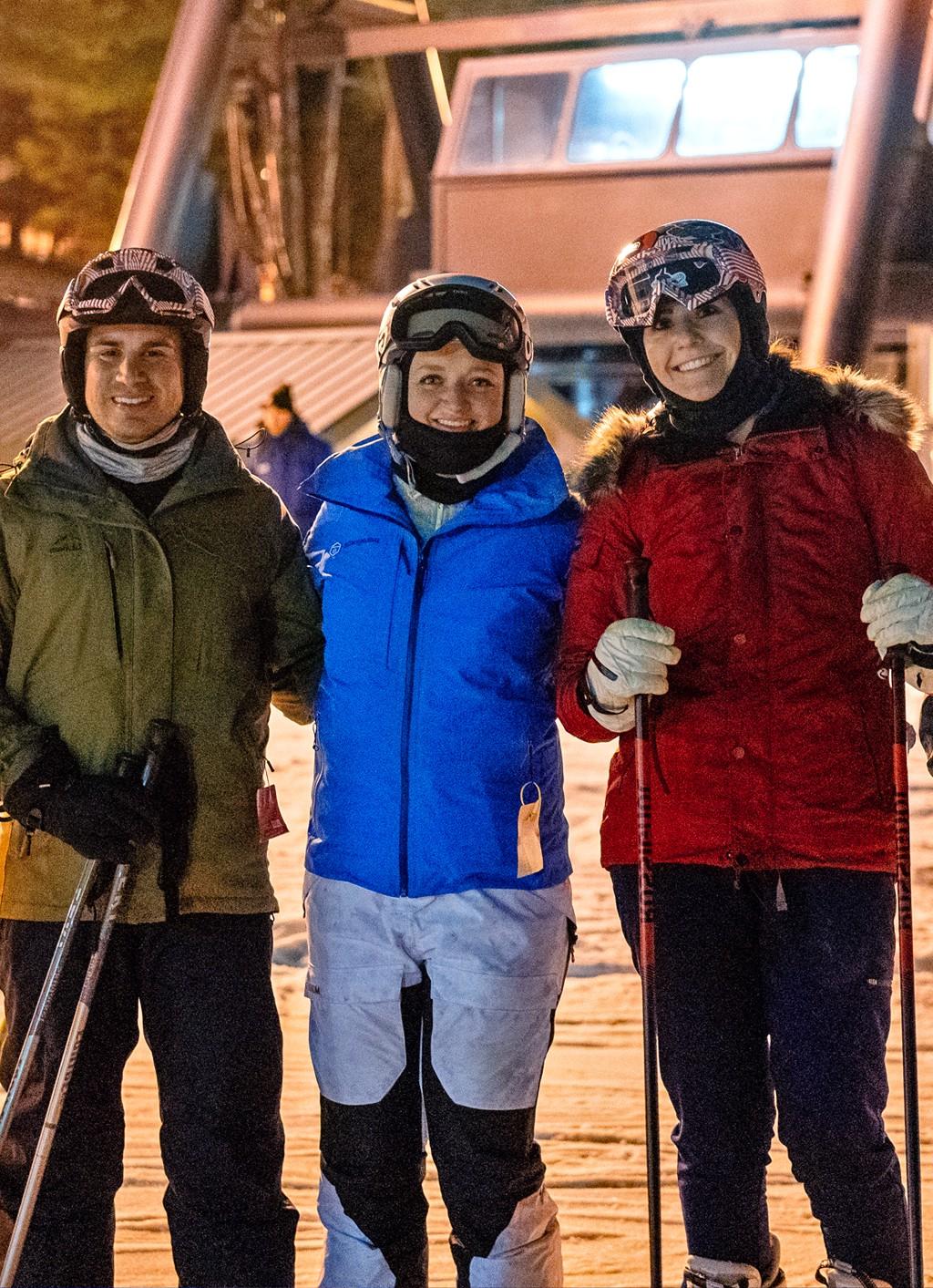 三个东北大学的学生在一次滑雪旅行中在雪山上拍照