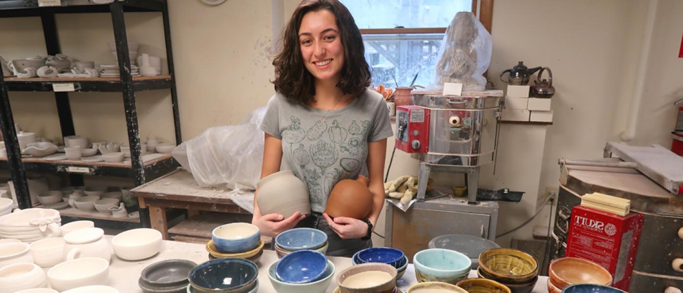 一名东北大学文科学生站在她在美术课上制作的陶器前